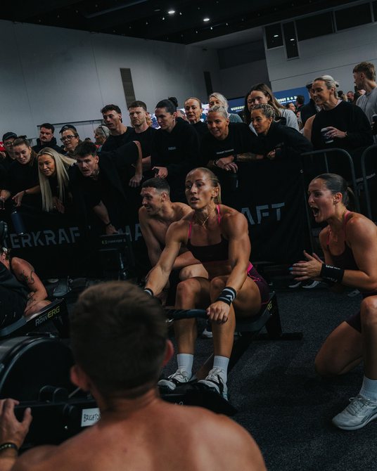Athletes racing on ergs in front of the crowd at Race The Globe